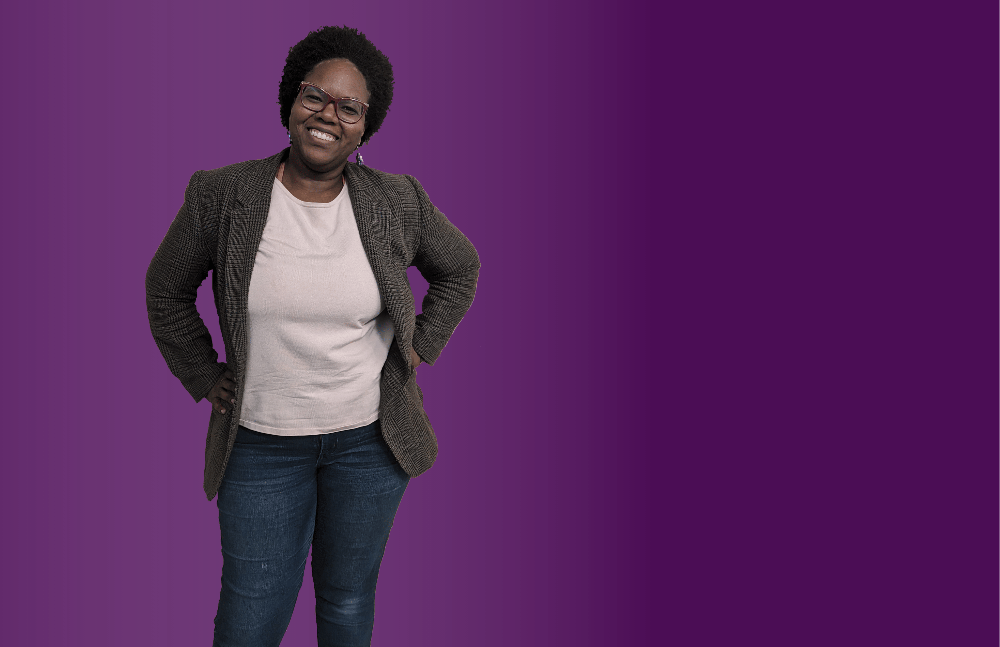 Corvallis Councilor Briae Lewis standing and smiling with a purple background